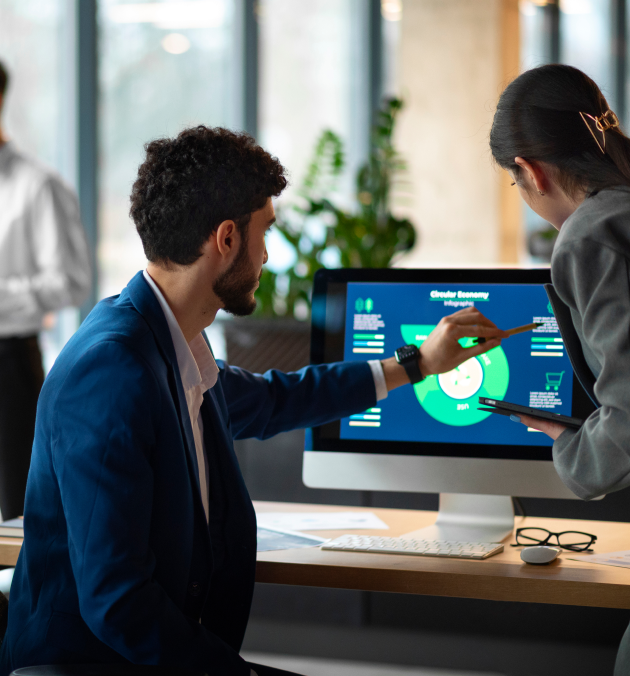 Office workers reviewing data on a monitor