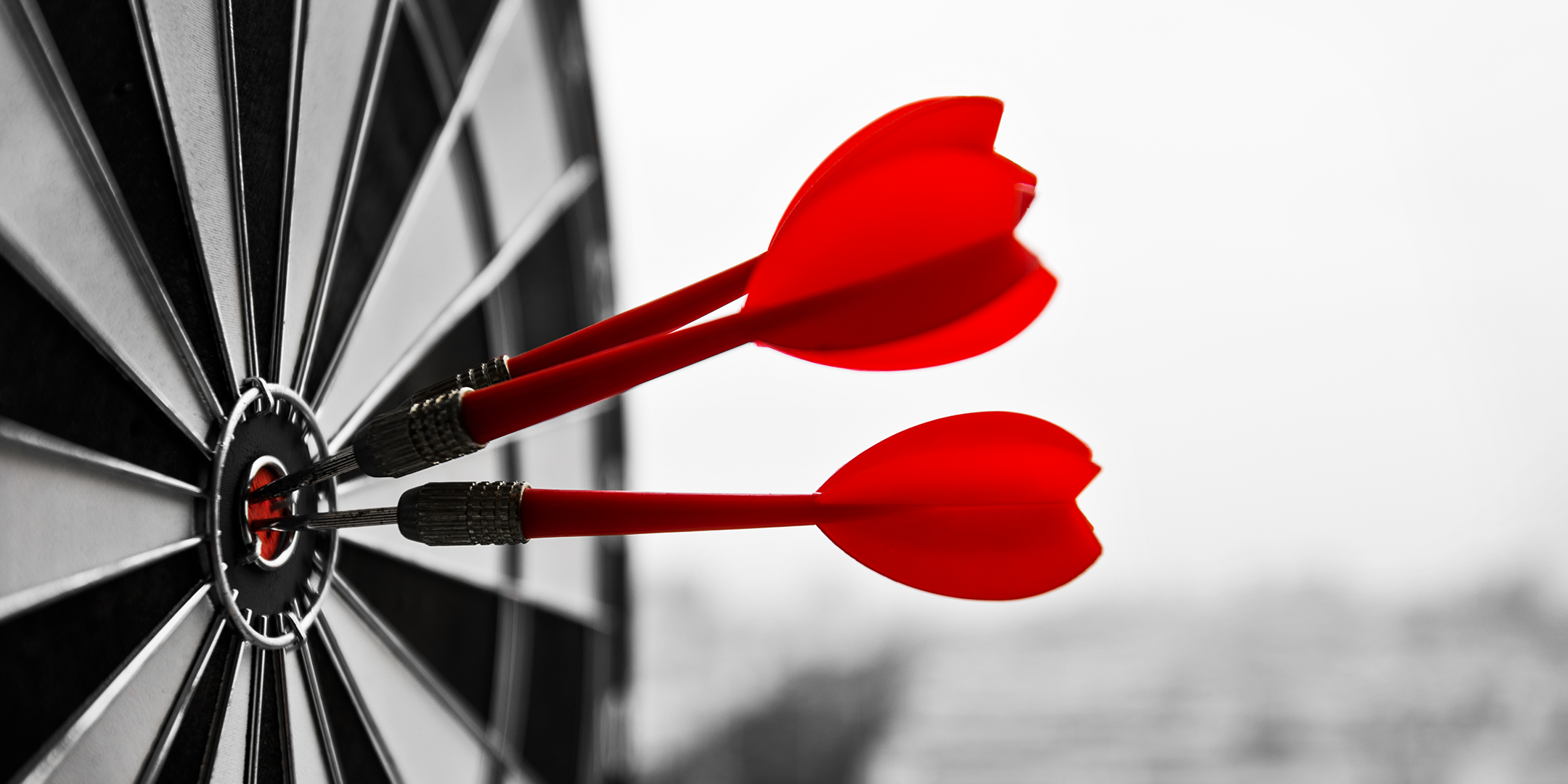 red darts hitting a dartboard