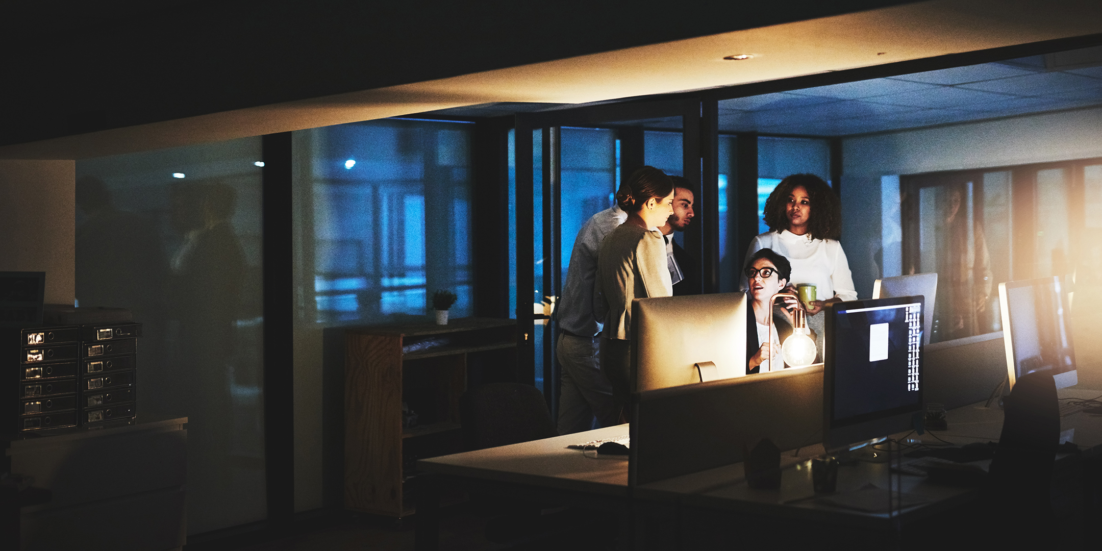 Security professionals gathered around a computer at night.